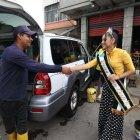 Un trabajador del lavado de vehículos en la zona detiene su actividad para saludar a la reina del club emblema de la barriada, el River Oeste.