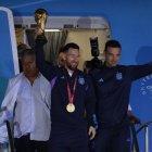 Lionel Messi de la selección argentina de fútbol saluda con el trofeo del Mundial de Fútbol Qatar 2022 junto al seleccionador Lionel Scaloni (d) a su llegada, al Aeropuerto Internacional de Ezeiza.