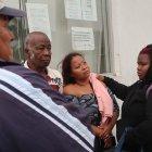 Karen Plúas (centro) presenció el crimen de su esposo y padre de sus hijos. Sus familiares le dan consuelo.