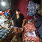 La mujer utiliza un andador para desplazarse en su cuarto estrecho.Mariana usa la misma cama para hacer tareas.