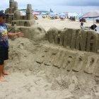 Cristhian Quinde muestra el castillo de arena que fue destruido por los carnavaleros.