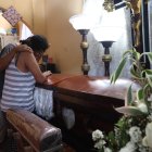 Lady Troya llora desconsolada ante el féretro de Steven Oswaldo, el tercero de sus hijos. Es consolada por Miguel, el mayor de sus descendientes.