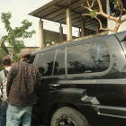 Las personas se aglomeran cerca de los vehículos en la calle Ayacucho
