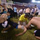 Fanáticos auxilian a personas durante una estampida en el Estadio Cuscatláán previo a un partido de la Liga Mayor, en San Salvador (El Salvador).