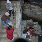 Hombres, mujeres y niños trabajan en la regeneración de Miraflores Alto 2, en el noroccidente de Quito.