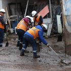 Gente de La Comuna empieza a sacar el lodo de las calles y casas.