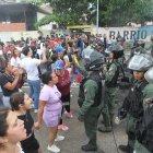 Personas reclaman frente a integrantes de la Guardia Nacional Bolivariana (GNB).
