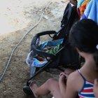 La niña contempla a su bebé en un pequeño coche. Ella le puso los nombres que más le gustaban.