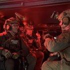 Agentes armados dentro de una camioneta, durante el inicio de una redada contra indocumentados.