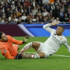 El delantero francés del Real Madrid, Kylian Mbappé (d), remata ante el guardameta brasileño del Manchester City, Ederson Moraes.