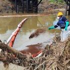 Un contingente arroja polvo absorbente al agua para combatir los residuos del crudo.