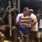 Un ciudadano lleva varias cubetas de huevos que sacó del camión que se volcó en la carretera E15, en la parroquia San Mateo.