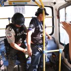 Policías revisan a los pasajeros de un bus durante un operativo.