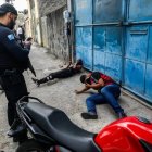 Dos hombres son custodiados por agentes de la Policía de Río durante el mega operativo.