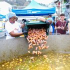 Un grupo de mujeres agrega chorizo ahumado al Tapao Arrecho más grande dle mundo preparado este sábado en Esmeraldas.