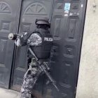 Un uniformado ingresa por la fuerza a un inmueble durante los operativos para capturar a los policías señalados en corrupción.