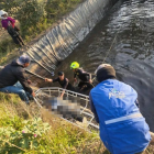 Bomberos locales mientras sacan el cuerpo de un menor de un reservorio en Guamote.
