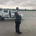 Un agente de la Policía Nacional resguarda la escena donde fue hallado un cuerpo decapitado y sin extremidades en la playa de Muisne, sector La Pocita
