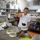 En la cocina de El Tiburón, Alberto Mero sirve gustoso un plato de encebollado a sus clientes.