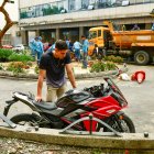 Carlos Burgos mientras revisa los daños que sufrió su motocicleta.