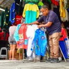 Diego Calderón muestra los impermeables con estampados para niños que comercia.