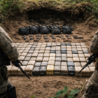 Recreación de un cargamento de droga y armas oculto en una caleta en zona selvática.