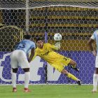 Rafael Romo (c) de U. Católica se lanza por el balón en la tanda de penales en el partido de vuelta por la primera fase de la Copa Libertadores ante Juventud.