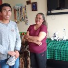 Bryan posa junto a su madre, Patricia Bazurto, mientras sostiene uno de los zapatos de competencia que compró hace cinco años con sus propios ahorros.