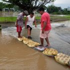 Pobladores de la parroquia Vernaza colocan sacos con arena para tratar de contener el agua.
