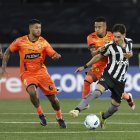 Byron Castillo (c) intenta retener a un rival entre Barcelona y Botafogo.