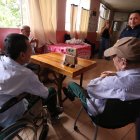 Adultos mayores escuchan y conversan con el asistente de IA durante la actividad organizada por estudiantes e investigadores universitarios.