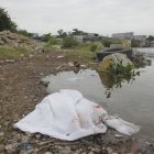 Cuerpo de mujer hallado a orillas del estero Salado, cubierto con una sábana mientras esperan a la Policía Nacional