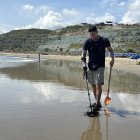 Bryan Zambrano mientras recorre la playa de San Mateo, en Manta, en busca de objetos de valor que quedan enterrados tras la marea.