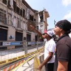 Ciudadanos se detienen a observar el deterioro de la Casa Tola, hoy convertida en un punto de riesgo.