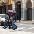 Calor extremo en Guayaquil: ciudadanos se protegen de los rayos solares directos.