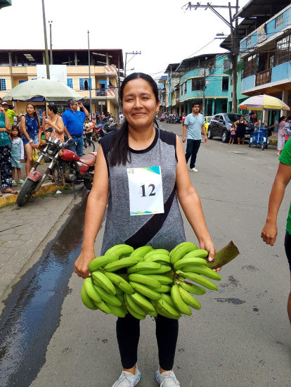 La ganadora de las mujeres mostró que para ella no es impedimento correr con un racimo de plátano.
